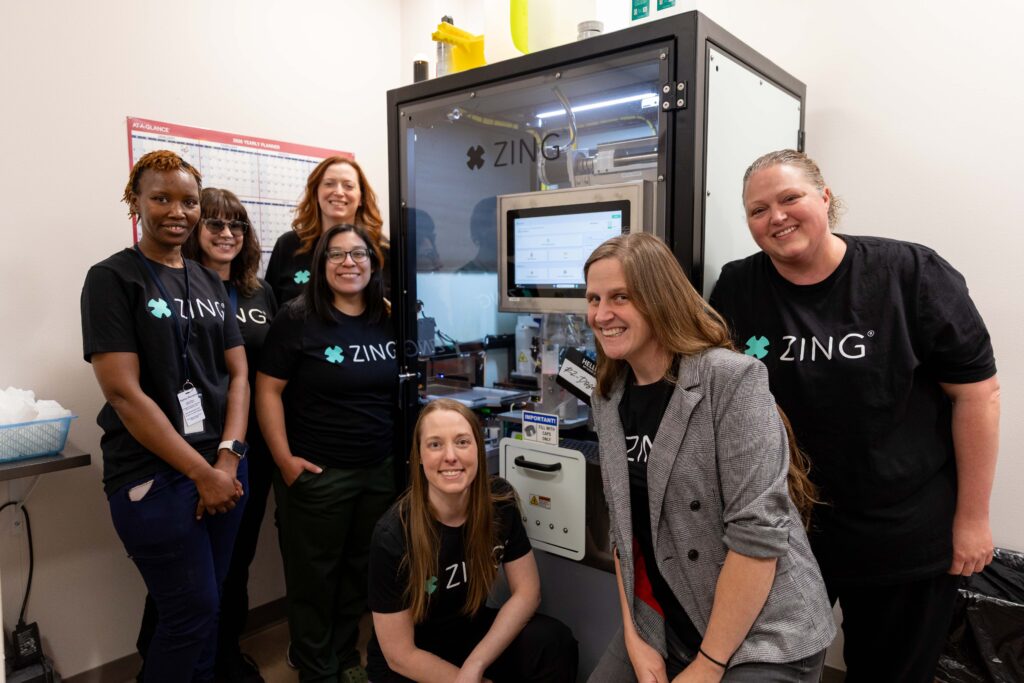 Comprehensive Healthcare staff pose with the ZING robotic methadone dosing system at the organization's Opioid Treatment Program clinic in Yakima.